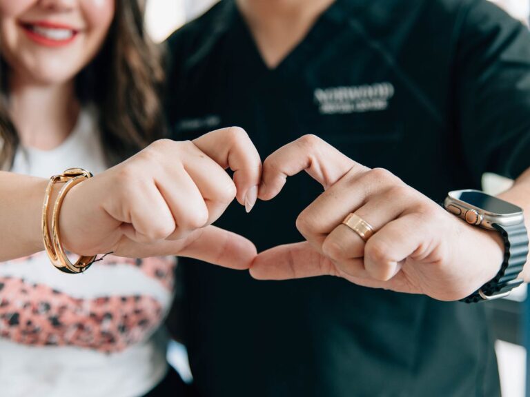 Two Norwood Dental Centre team members making a heart with their hands