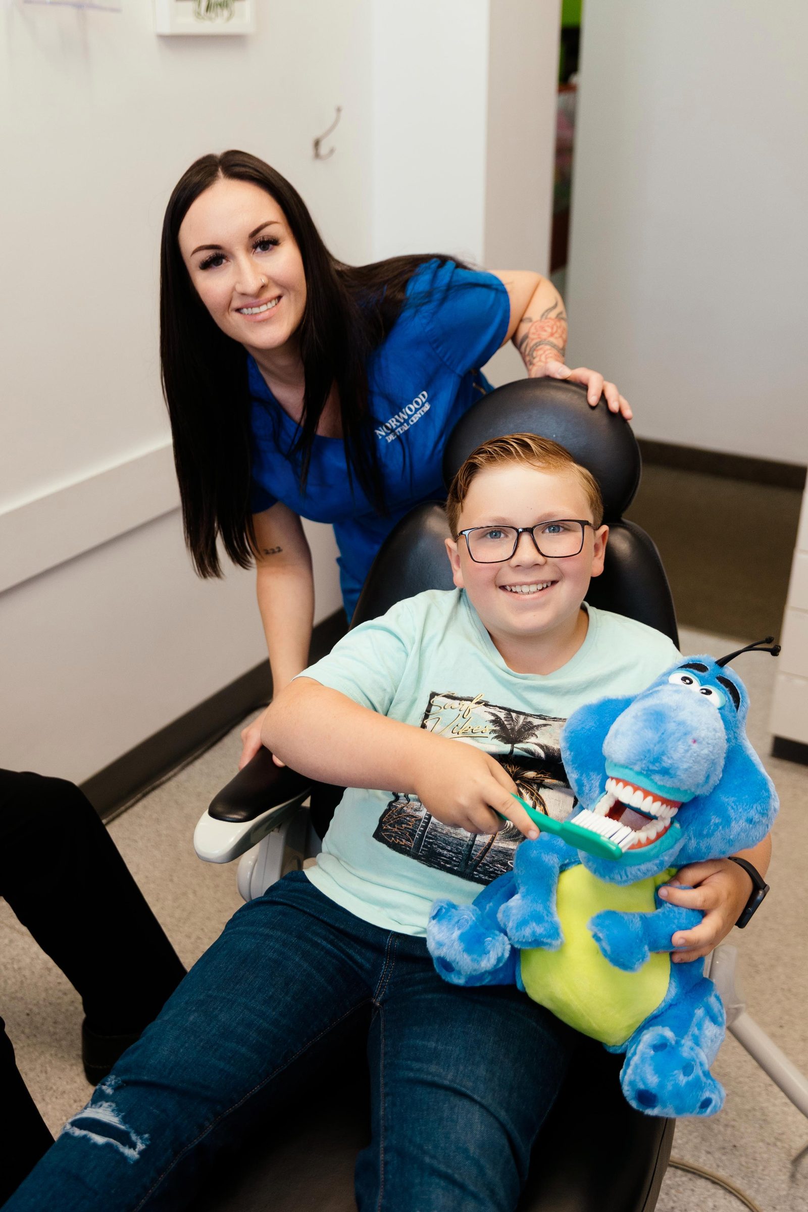 A young patient and a Norwood Dental Centre hygienist holding the brushing-practice toy